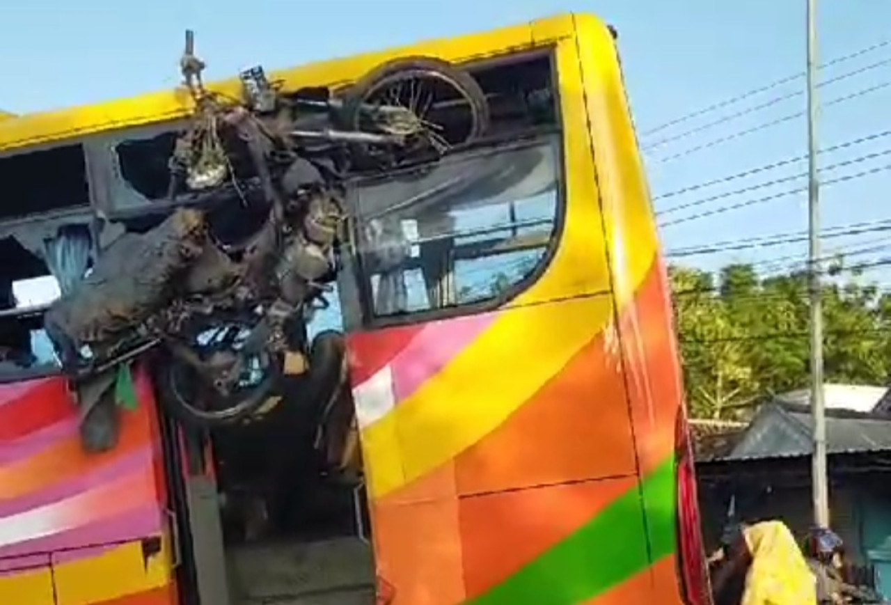 Kondisi bus yang terguling setelah menabrak pemotor di Jalan Raya Bojonegoro Babat. (Foto: tangkapan layar video amatir warga)