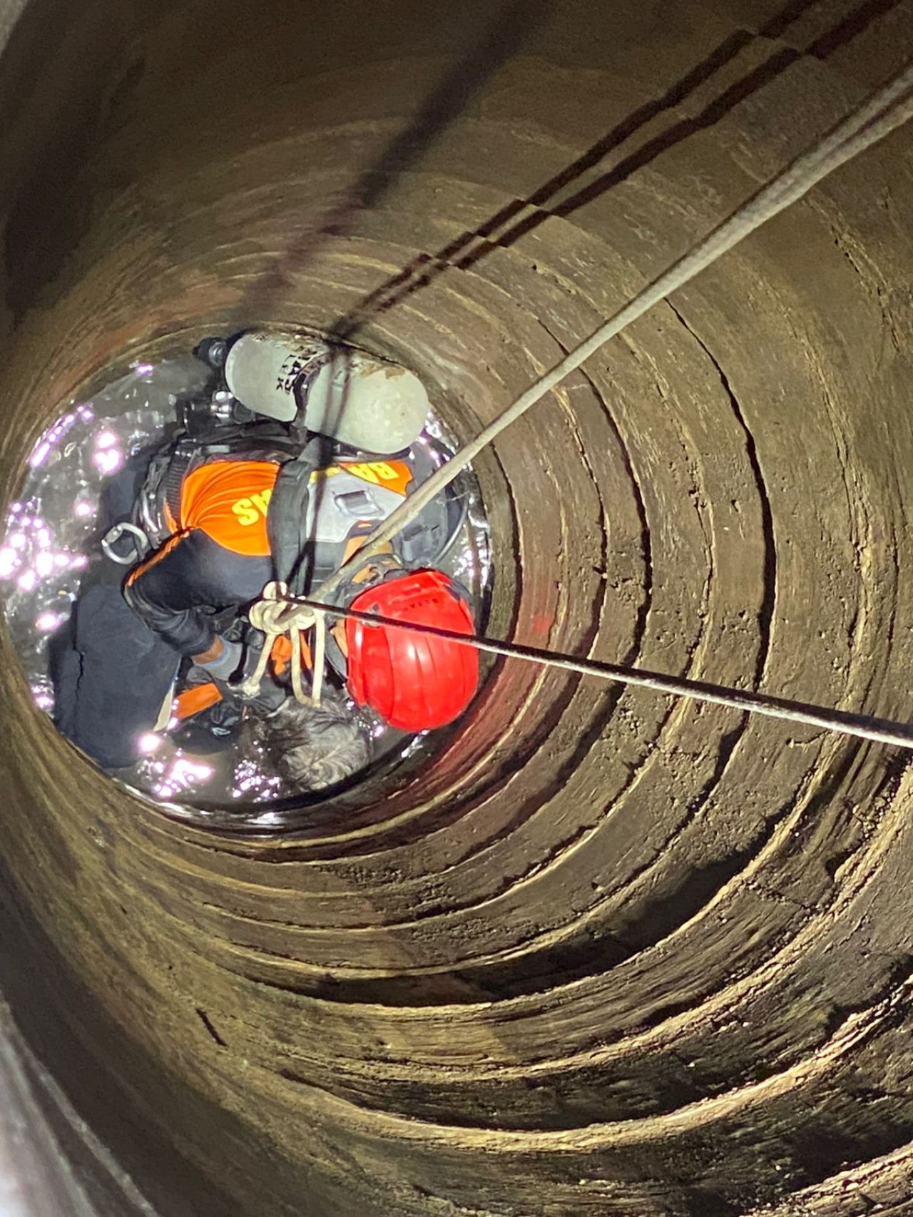 Petugas saat berupaya mengevakuasi korban dari dalam sumur. (Dok Pos Basarnas Trenggalek for jatimnow.com)