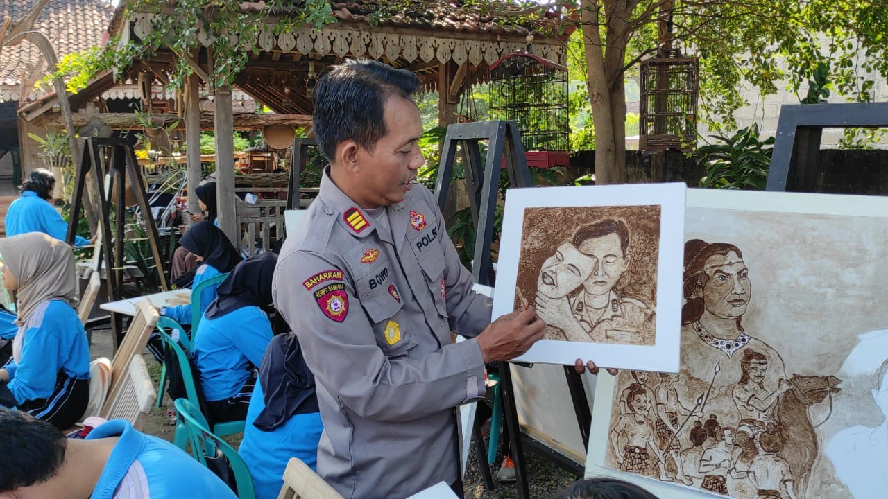 Kapolsek Plemahan AKP Bowo Wicaksono saat mengajar siswa melukis dengan ampas kopi. (dok. Pribadi)