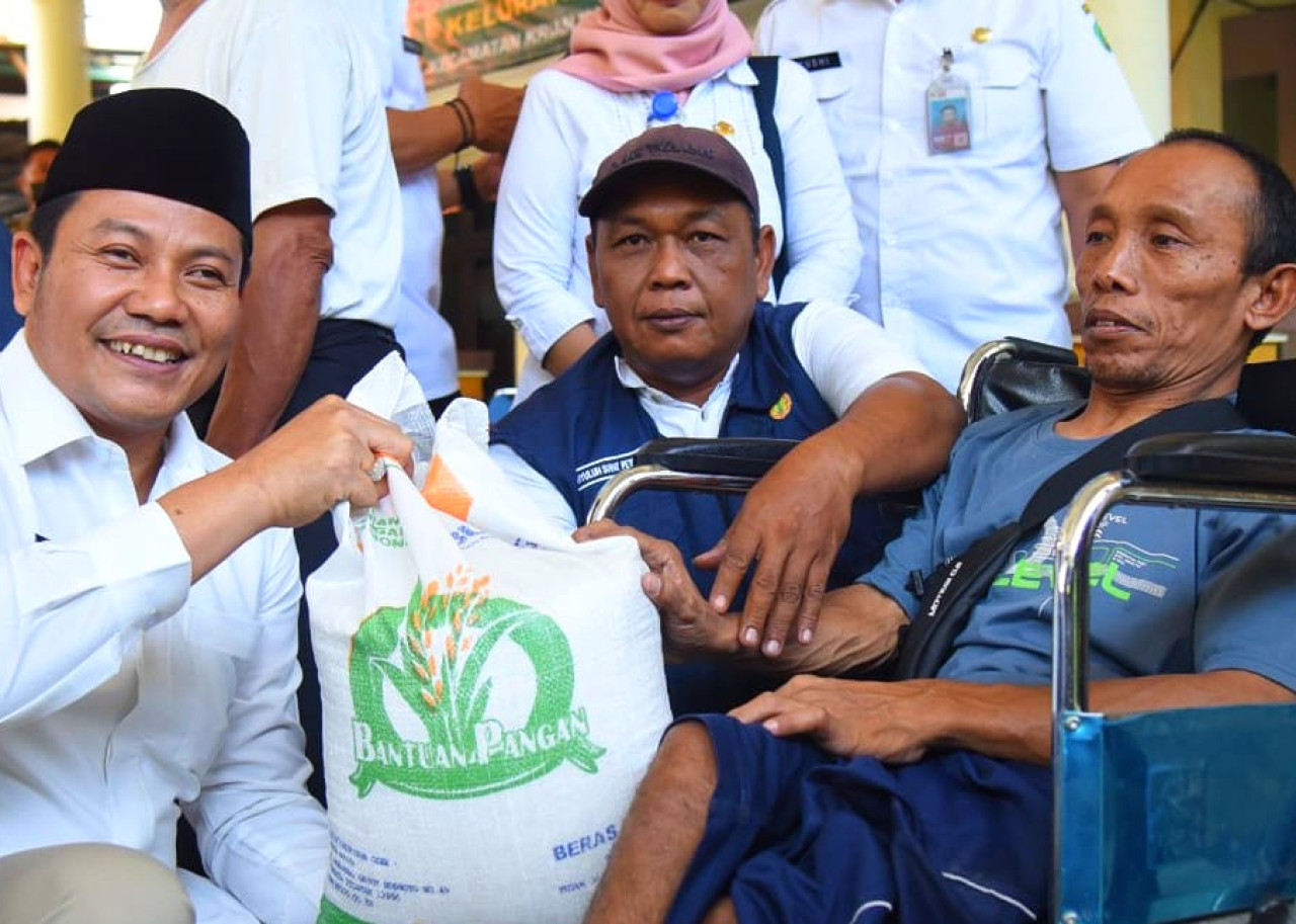 Plt Bupati Sidoarjo H Subandi saat menyerahkan bantuan beras. (Foto: Ahaddiini HM/jatimnow.com)