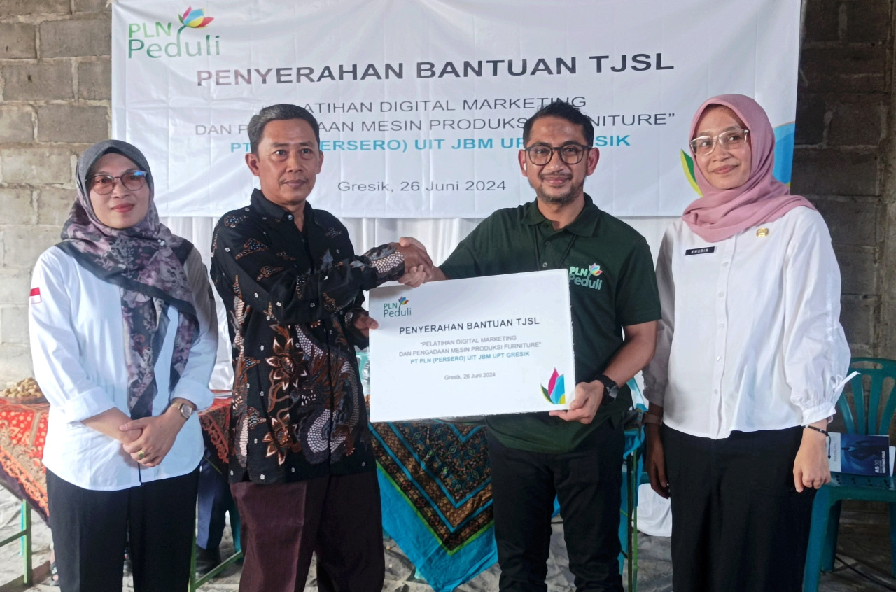 Manajer PLN UPT Gresik yang diwakili Luky Adi Pamungkas (dua dari kanan) saat memberikan bantuan secara simbolis bantuan Tanggung Jawab Sosial dan Lingkungan (TJSL) kepada Ketua Koperasi Kriya Giri Sejahtera, Heriyanto, di Desa Domas, Kecamatan Menganti. 