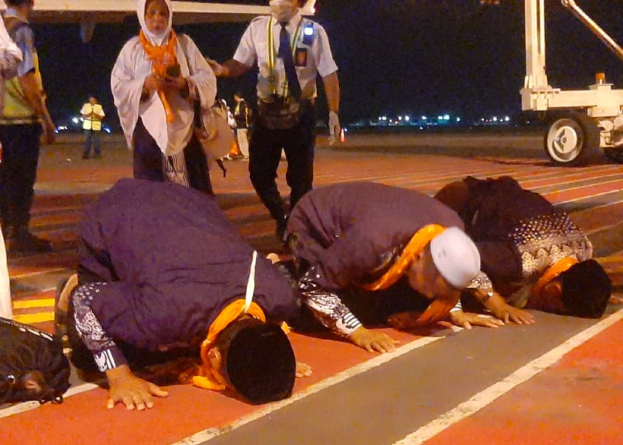 Sujud syukur para jamaah haji kloter I Debarkasi Jawa Timur saat tiba di Bandara Udara Juanda. (Foto: Ahaddiini HM/jatimnow.com).
