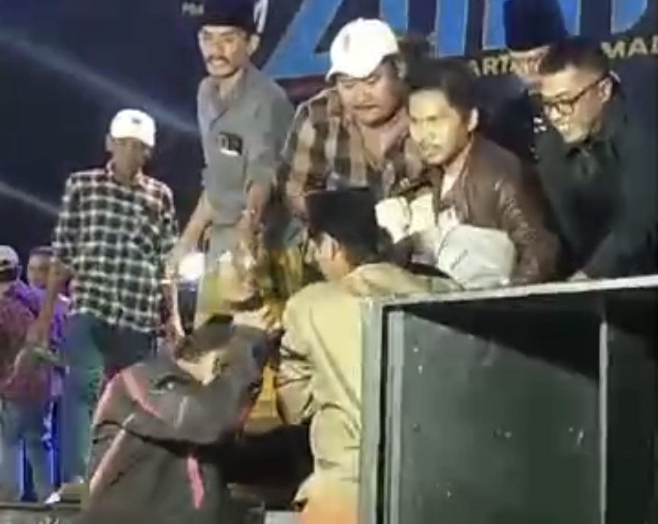 Roni diturunkan dari panggung saat jatuh pingsan di Bangkalan. (Foto: tangkapan layar video warga for jatimnow.com)