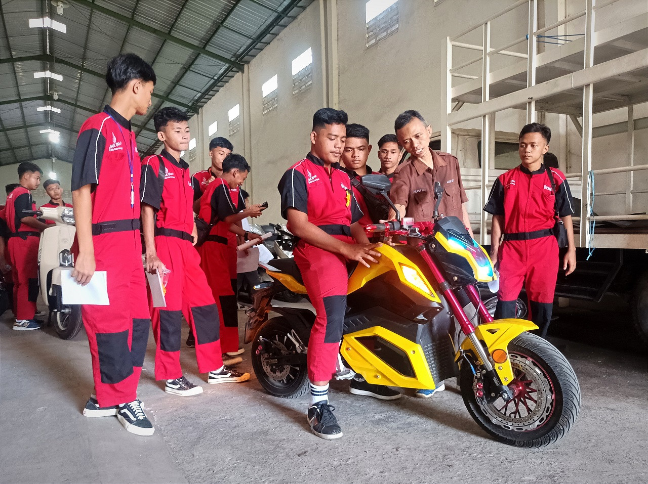 Para siswa SMK NU Ma'arif Doro Pekalongan sedang mencoba salah satu unit motor listrik produksi Molindo. (Foto: Sahlul Fahmi/jatimnow.com)