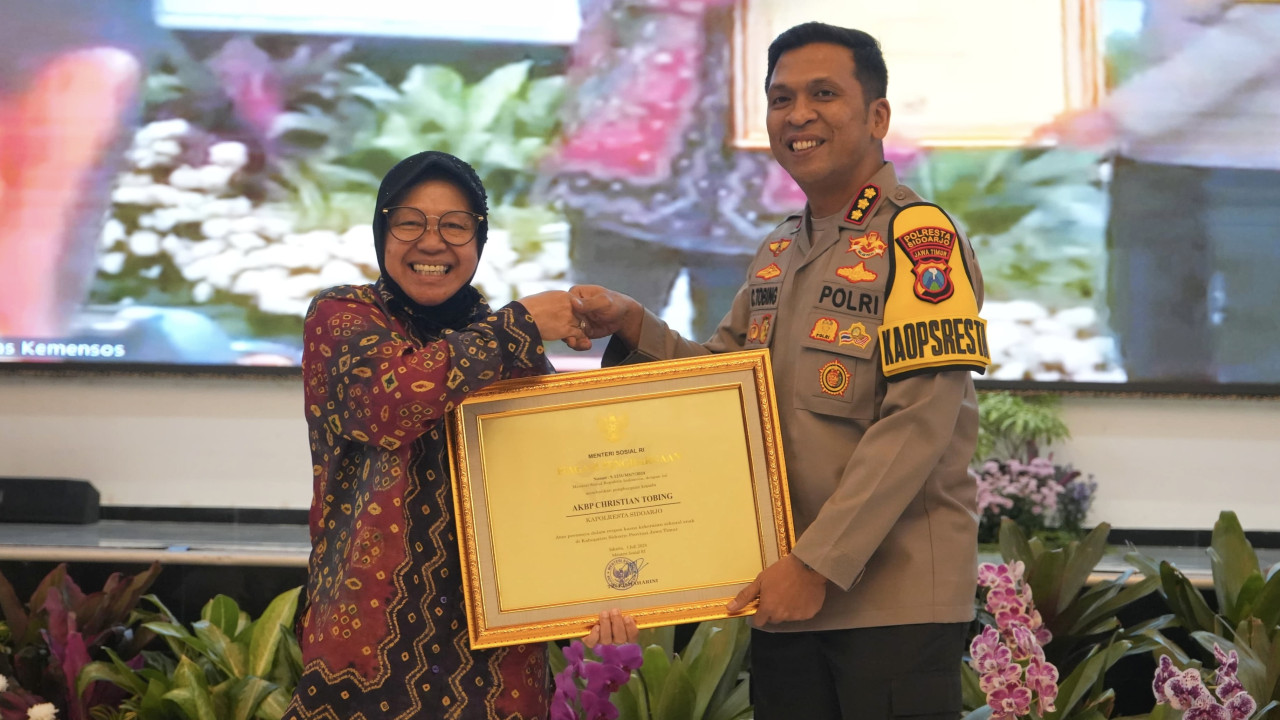 Kapolresta Sidoarjo Kombes. Pol. Christian Tobing saat menerima penghargaan dari Menteri Sosial Tri Rismaharini. (Foto: Humas Polresta Sidoarjo/jatimnow.com)