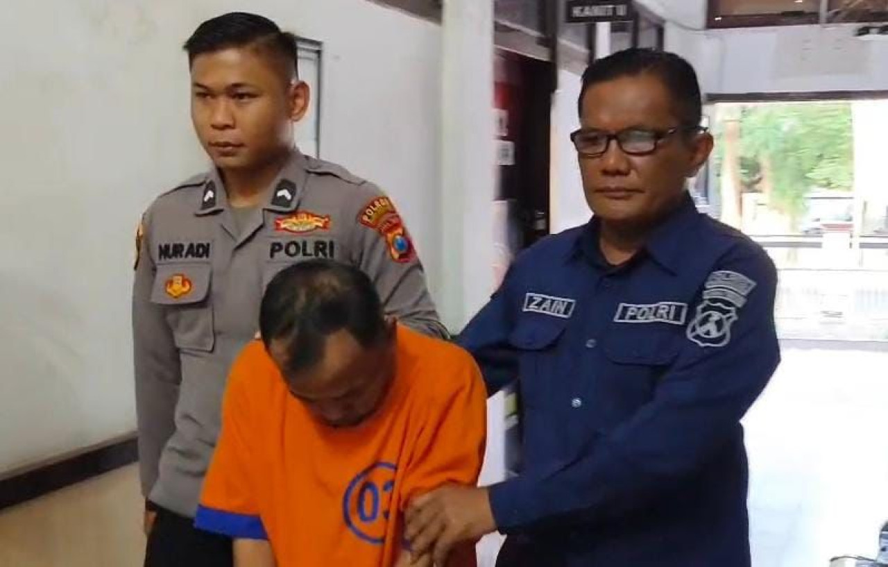 Kepala Desa Muneng Kidul saat digelandang polisi. (Foto: Humas Polres Probolinggo kota for jatimnow.com)