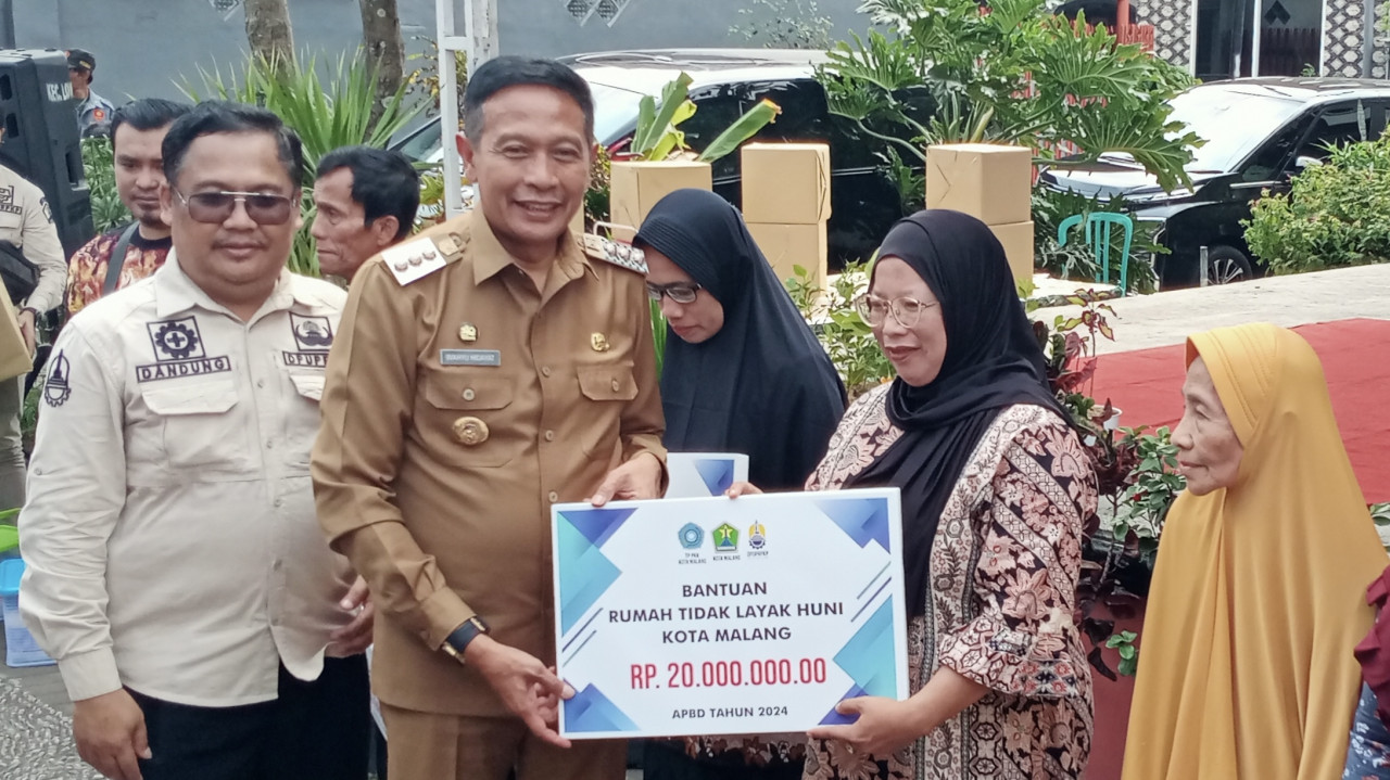 Pj Wali Kota Malang, Wahyu Hidayat menyerahkan secara simbolis bantuan Rumah Tidak Layak Huni (RTLH). (Foto-foto: Gerhana/jatimnow.com)