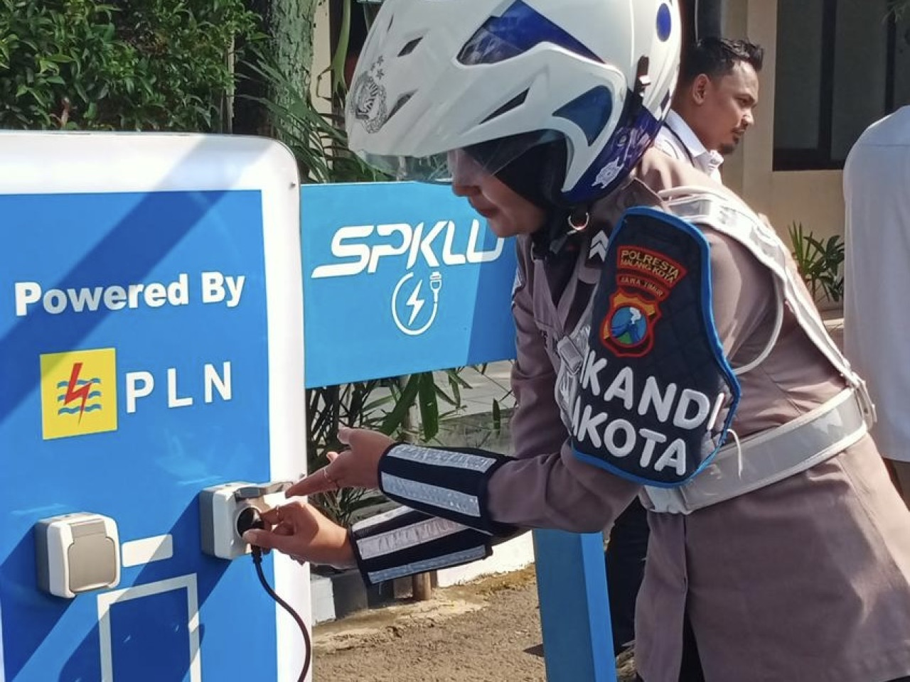 Petugas saat menggunakan SPKLU di Polresta Malang Kota. (Foto: Gerhana/jatimnow.com)