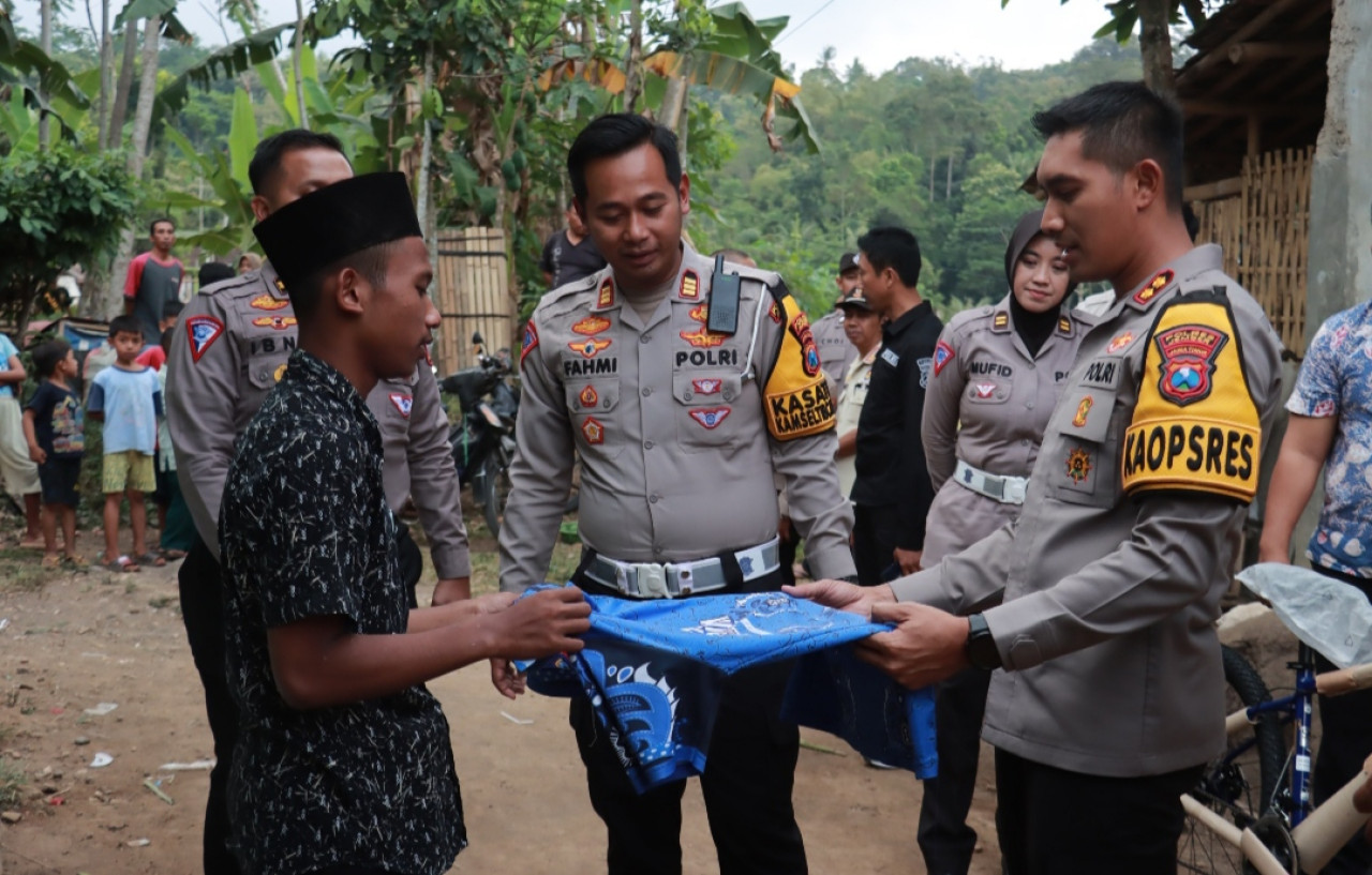 Alif Fathurrohman saat menerima bantuan dari Kapolres Jember AKBP Bayu Pratama Gubunagi (kanan). (Foto: Humas Polres Jember)