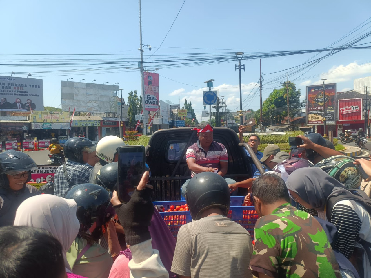 Jumantoro membagikan tomat gratis di depan Kantor DPRD Jember. (Foto: Sugianto/jatimnow.com)