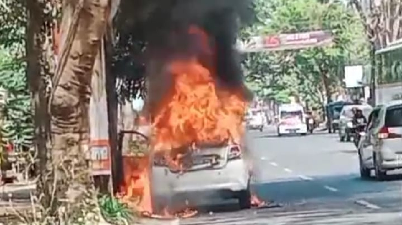 Petugas pemadam kebakaran usai memadamkan Datsun Go yang terbakar. (Foto: Polres Tulungagung)