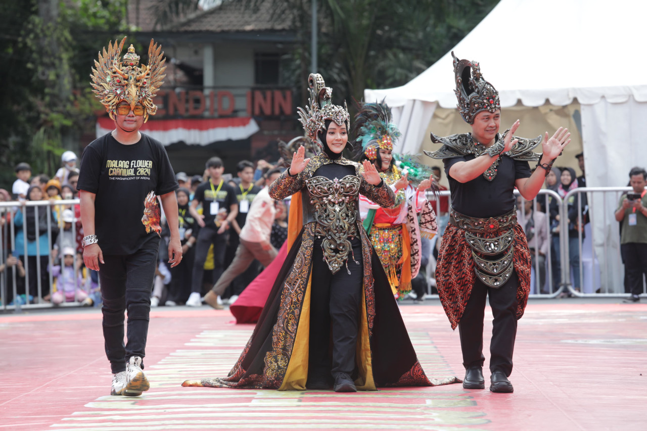 Pj Wali Kota Malang, Iwan Kurniawan (kanan) saat berpartisipasi dalam kegiatan Malang Flower Carnival 2024 di sekitar Balai Kota Malang pada Minggu (25/8/2024). (Prokopim Pemkot Malang)