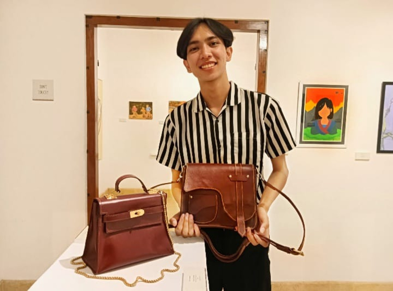 Ivan Zamzamy menunjukkan tas handmade kulit sapi jahit tangan hasil karyanya. (Foto: Ahaddiini HM/jatimnow.com)