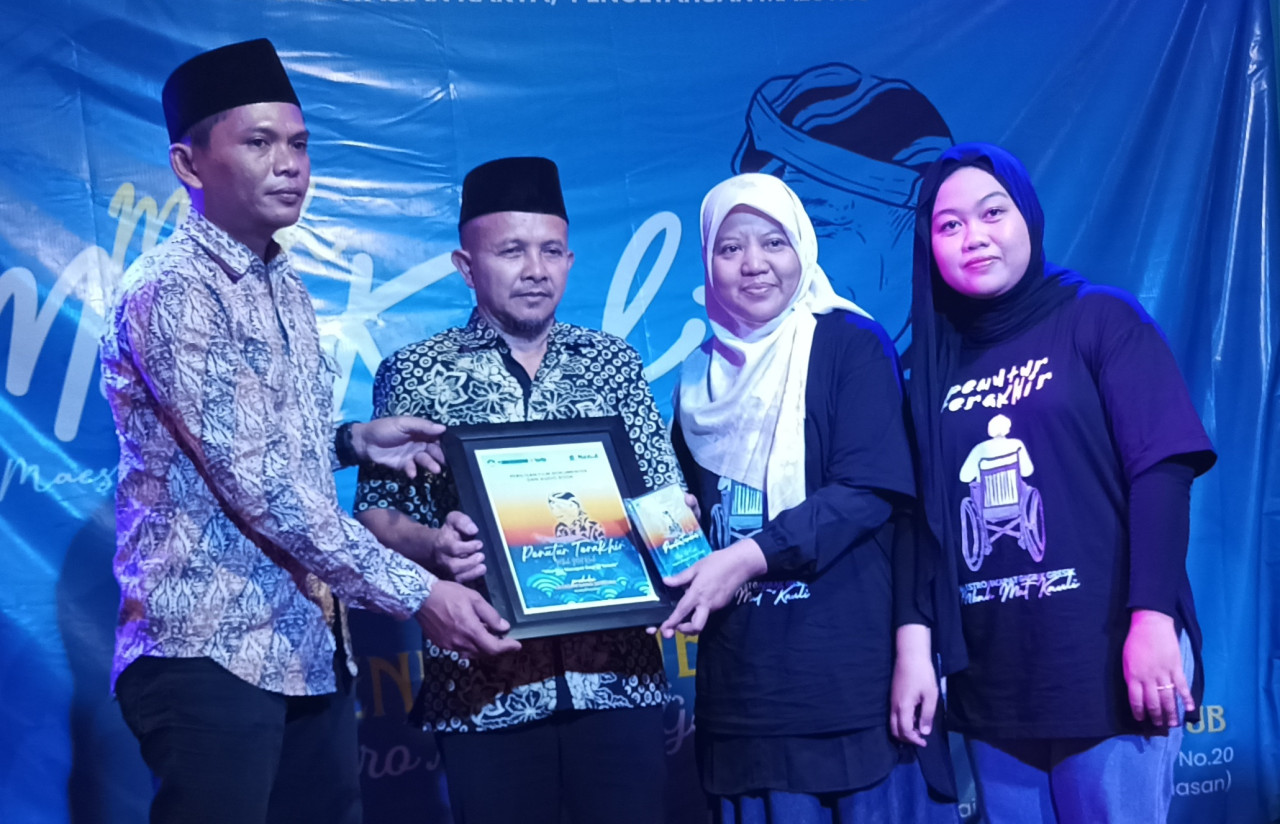 Uman Wahyudi (tengah), salah satu anak Mat Kauli, saat mewakili menerima penghargaan dari Yayasan Gang Sebelah di Kafe Sualoka, Kampung Kemasan Gresik. (Foto: Dok. Yayasan Gang Sebelah)