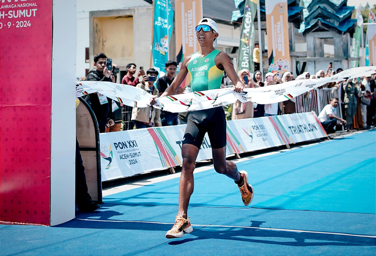Atlet Triathlon Jatim, Muhammad Noval Assidiq saat melewati gafis finis Triathlon nomor Standart Distance Putra PON XXI Aceh-Sumut. (Foto: KONI Jatim for jatimnow.com)