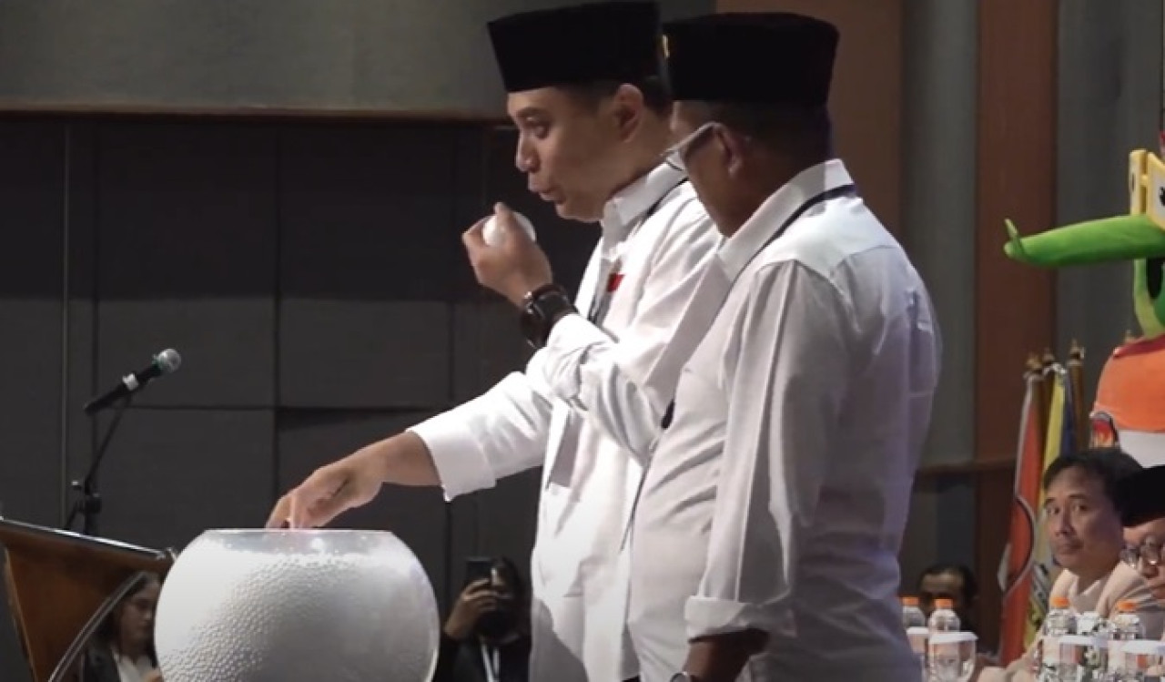 Eri Cahyadi meniup bola saat pengundian nomor urut peserta Pilkada 2024. (Foto: tangkapan layar YouTube KPU Surabaya)