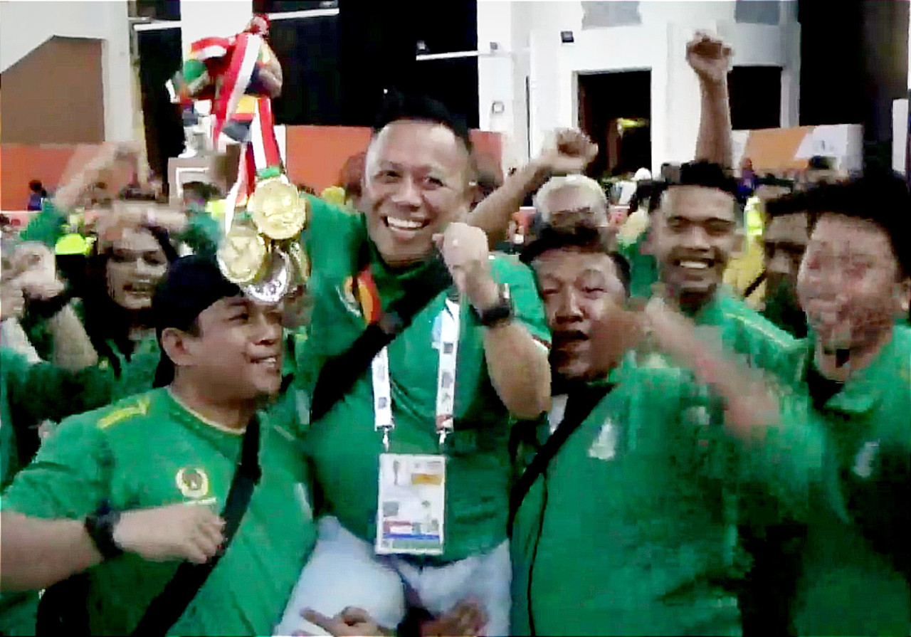 Ketua Muaythai Indonesia (MI) Jatim, Baso Juherman saat merayakan sukses tim Muaythai Jatim sebagai juara umum di PON XXI Aceh-Sumut 2024. (Foto: KONI Jatim for jatim now.com)