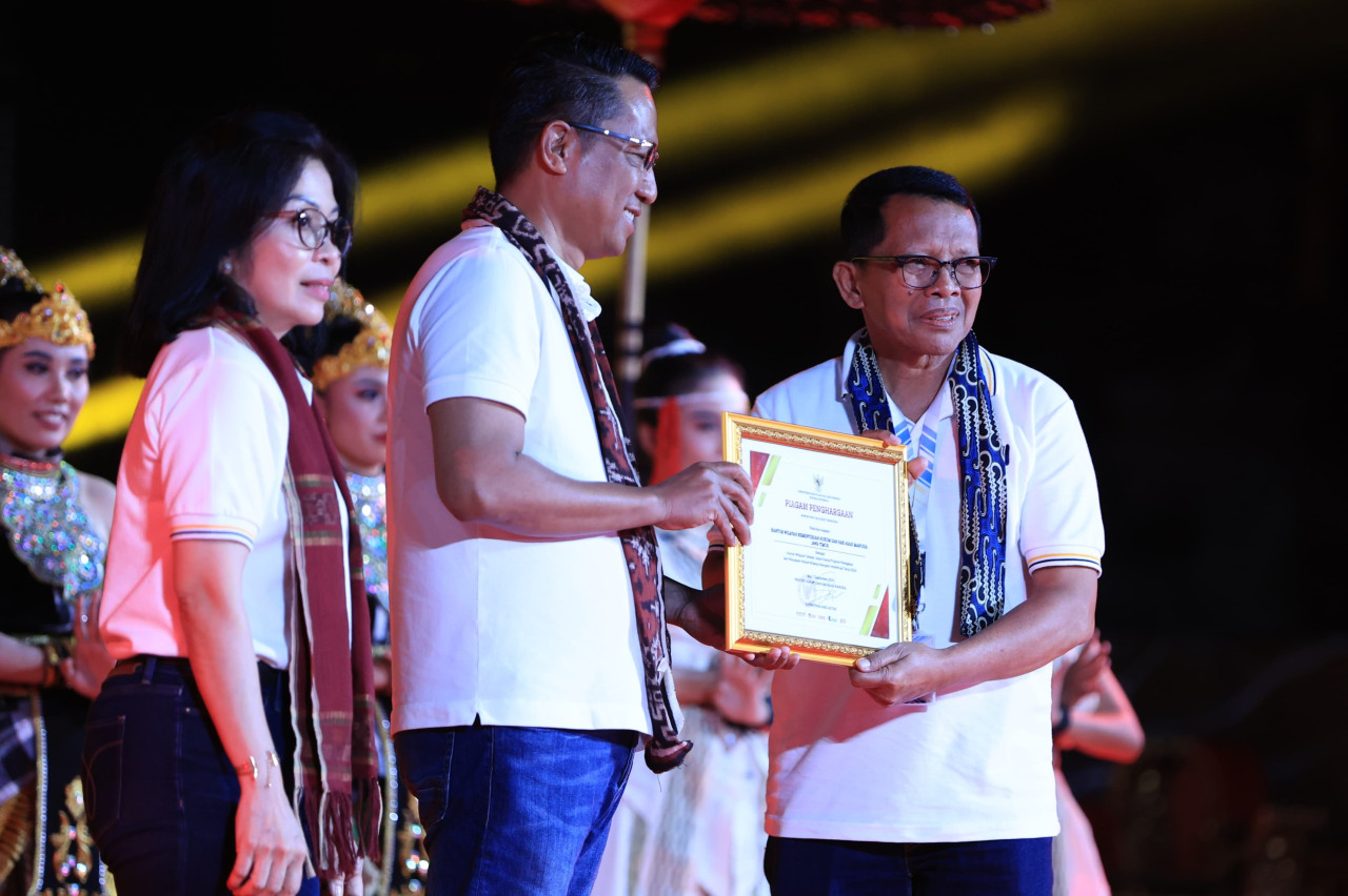 Menkumham RI Supratman Andi Agtas menyerahkan penghargaan secara langsung pada Kakanwil Kemenkumham Jatim Heny Yuwono (Foto: Humas Kemenkumham Jatim for jatimnow.com)