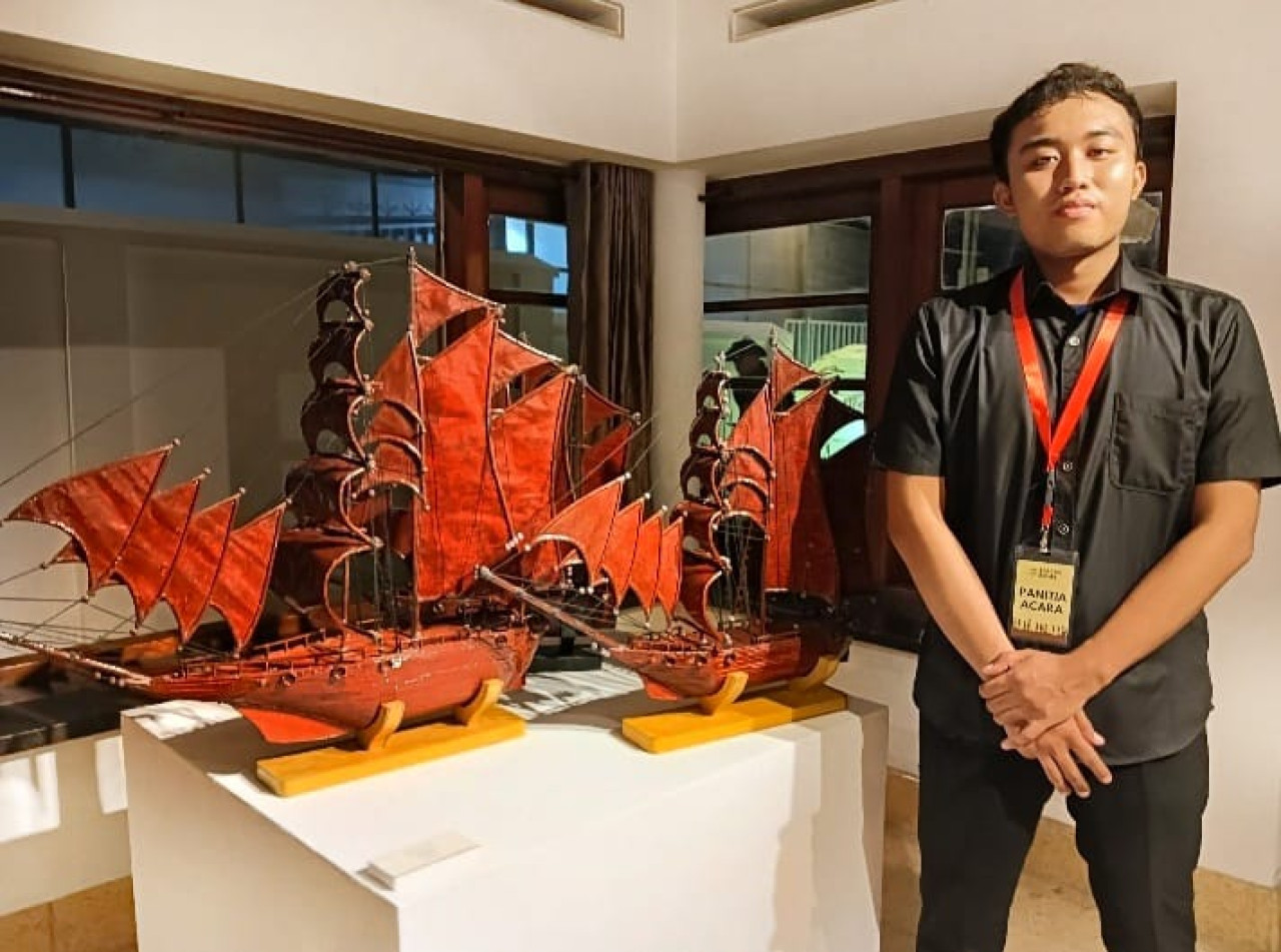 Ahmad Faiz Dur Rizki dengan miniatur kapal dari limbah kertas buatannya. (Foto: Ahaddiini HM/jatimnow.com).