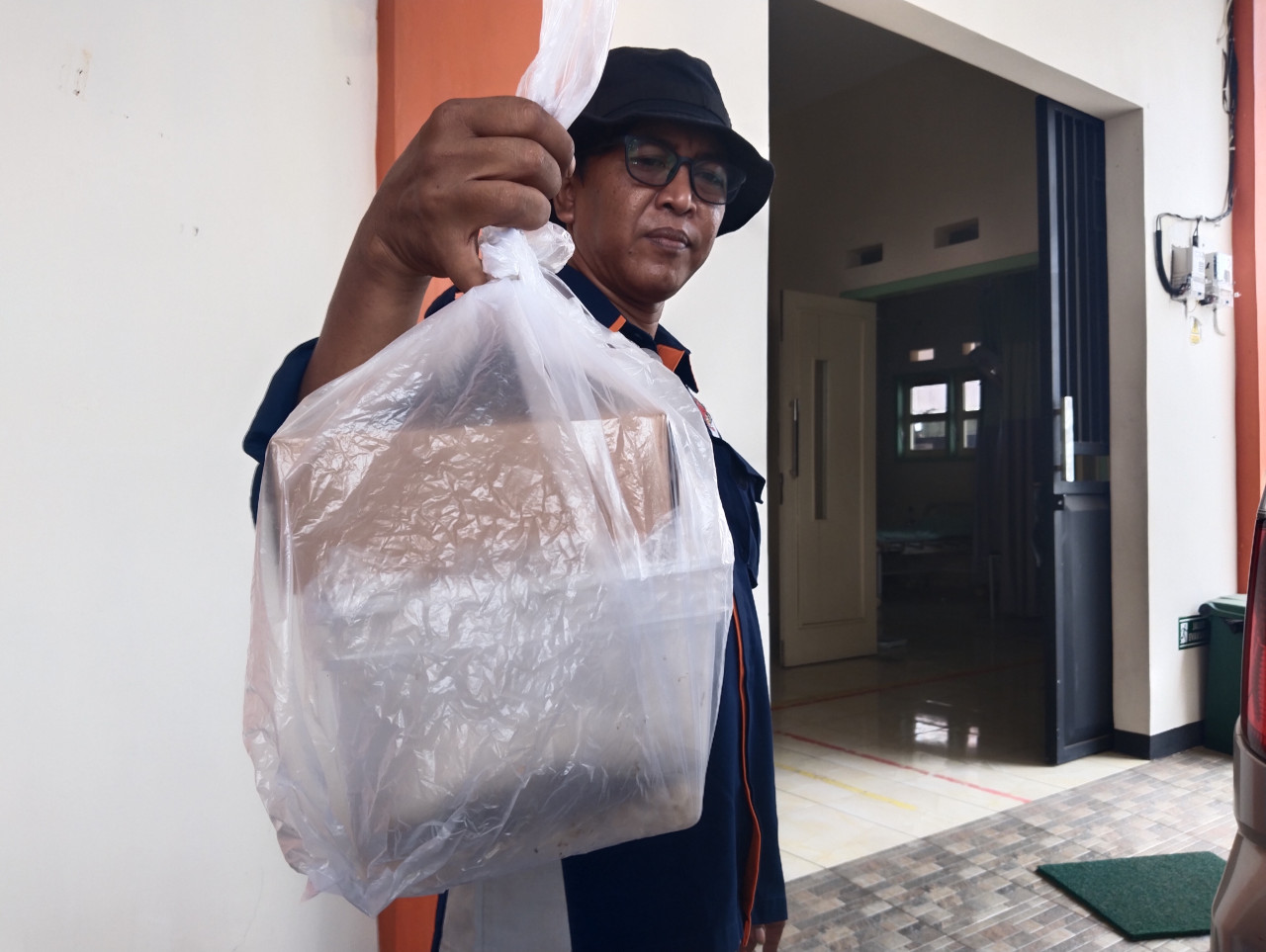 Polisi menunjukkan sisa nasi berkat hajatan yang dikonsumsi korban. (Foto: Bramanta Pamungkas/jatimnow.com)