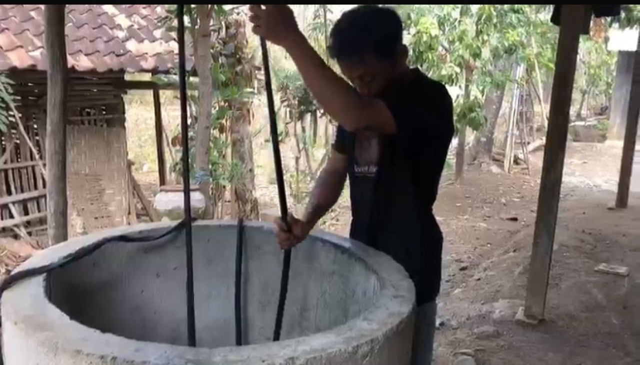 Warga Dungus Ponorogo menimba air sumur setelah hujan. (Foto: Ahmad Fauzani/jatimnow.com)