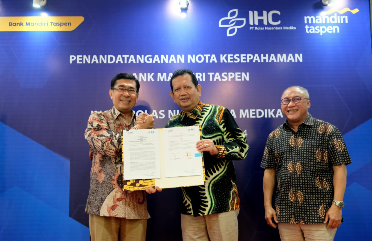 Direktur Bisnis Bank Mandiri Taspen, Maswar Purnama berjabat tangan dengan Direktur IHC PT ROLAS Nusantara Medika, dr Syamsul Bahri MPH MKK, disaksikan Komisaris IHC PT ROLAS Nusantara Medika, Bachtiar Novianto. (Foto: Ali for jatimnow.com)