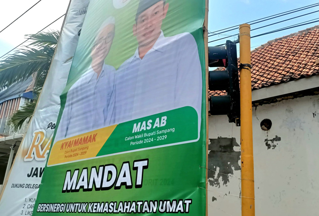 Baliho Paslon Mandat tutupi lampu lalu lintas. (Foto: Fathor/jatimnow.com)