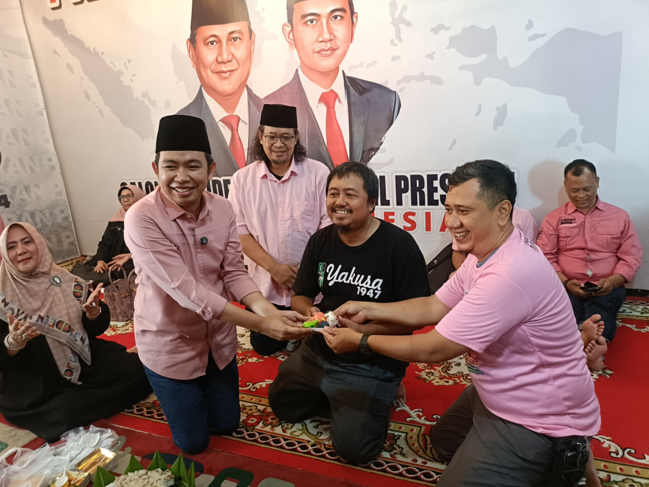 Gus Fawait memberikan potongan tumpeng ke pendukung Paslon 01 dan 03 saat Pilpres (Foto: Sugianto/jatimnow.com)