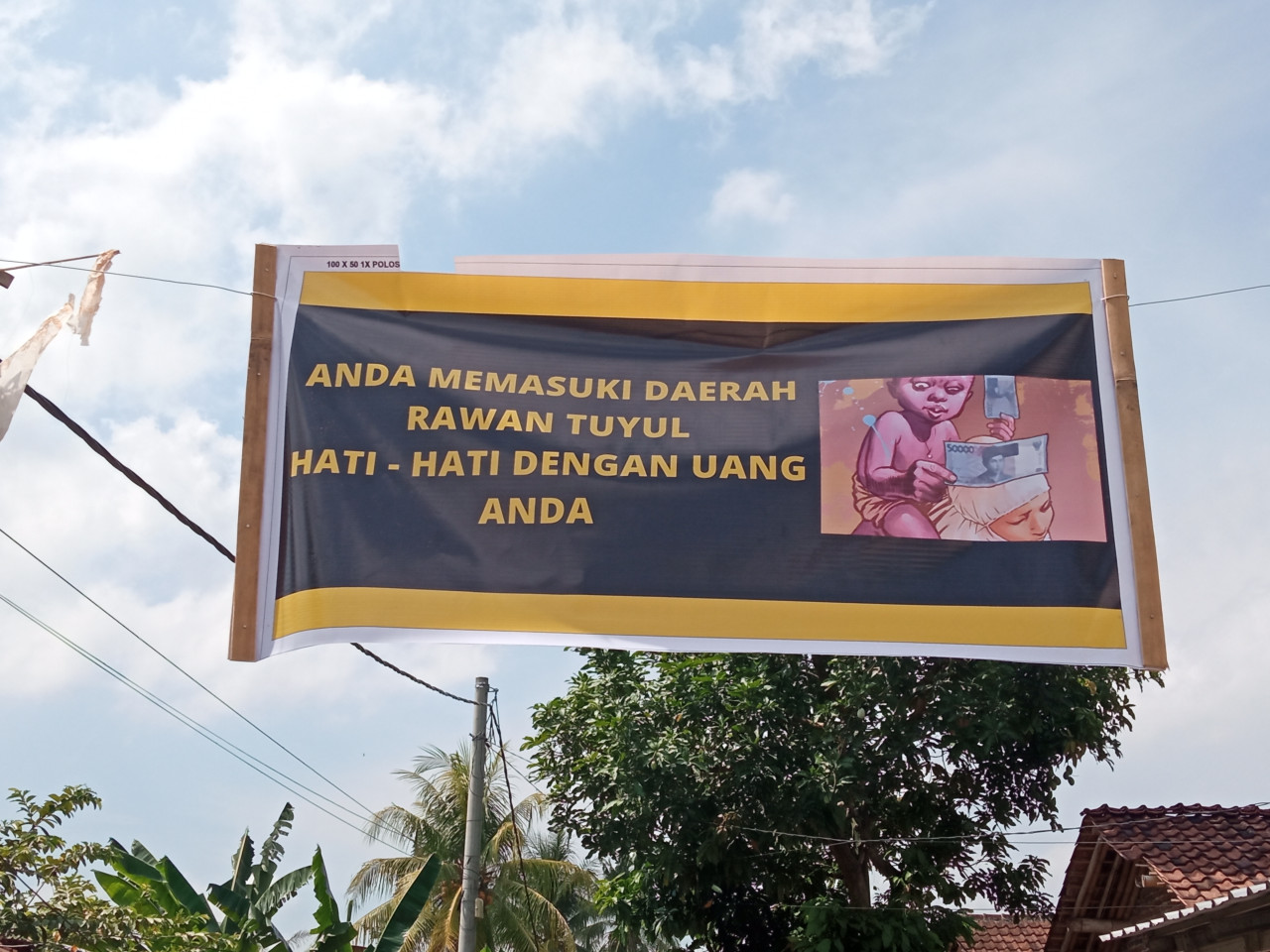 Spanduk tuyul mencuri uang rumah warga Dukuh Mencek terpampang di jalan. (Foto: Sugianto/jatimnow.com)