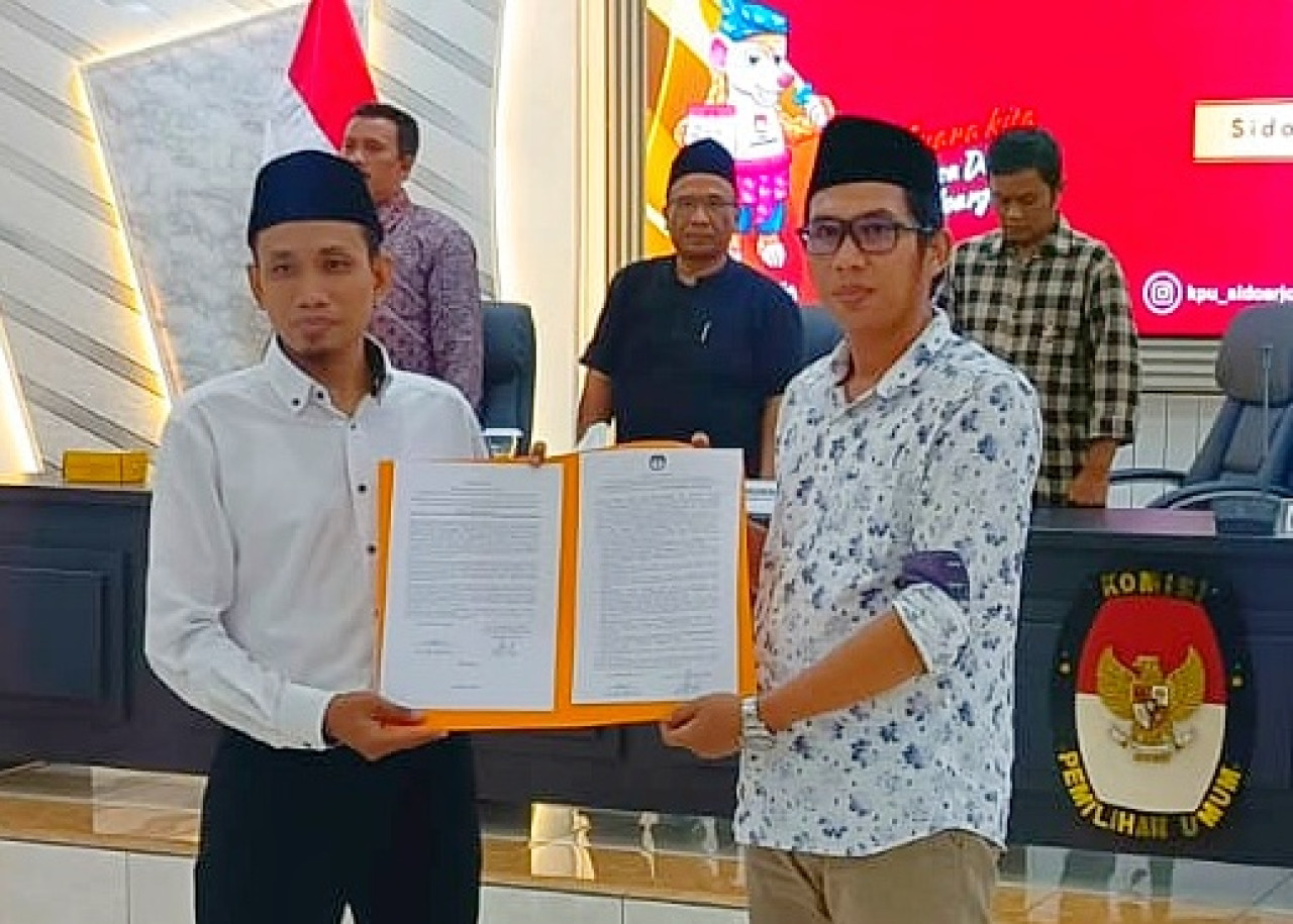 Ketua KPU Sidoarjo Fauzan Adhim saat melantik M. Anas Fachruddin, menggantikan Imrotus Solicha, melalui prosesi PAW sebagai anggota PPK Candi di aula KPU Sidoarjo. (Foto: Ahaddiini HM/jatimnow.com).