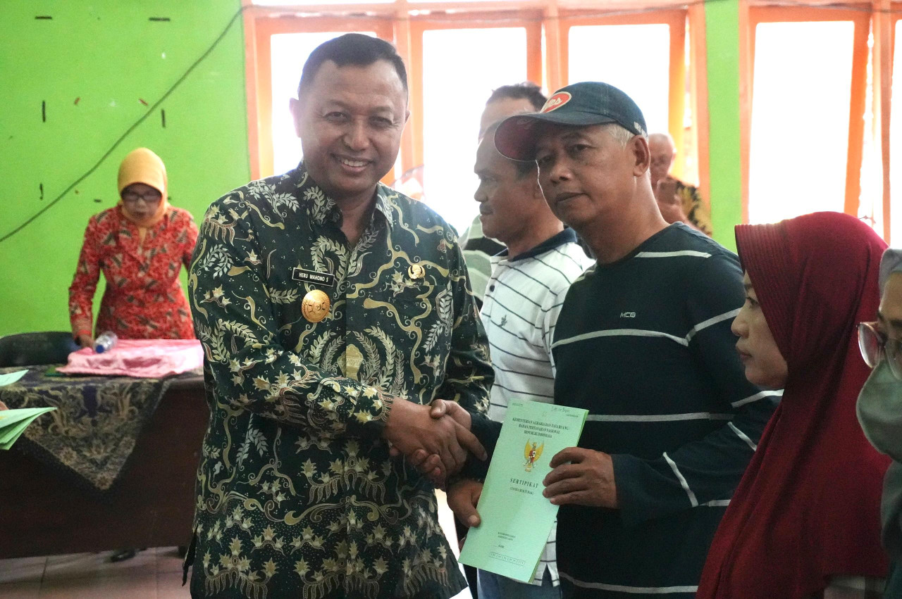 Pjs Bupati Heru Wahono Santoso menyalurkan sertifikat tanah dalam Program Pendaftaran Tanah Sistematis Lengkap (PTSL) di Kelurahan Pare. (Foto: Pemkab Kediri/jatimnow.com)