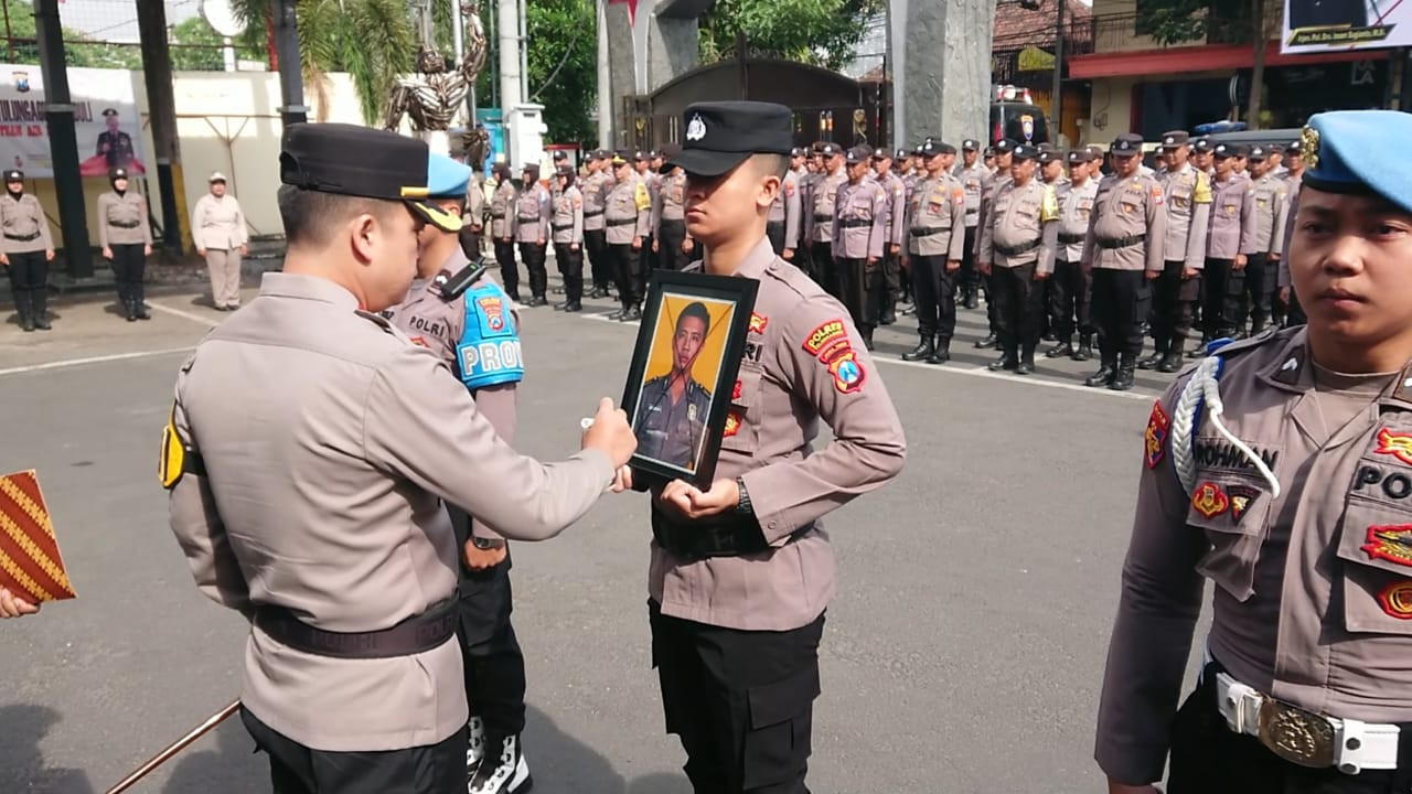 Kapolres Tulungagung, AKBP Taat Resdi mencoret foto Bripka Vengki Danar Bianto sebagai simbol pencopotan atribut. (Foto: Bramanta Pamungkas/jatimnow.com)