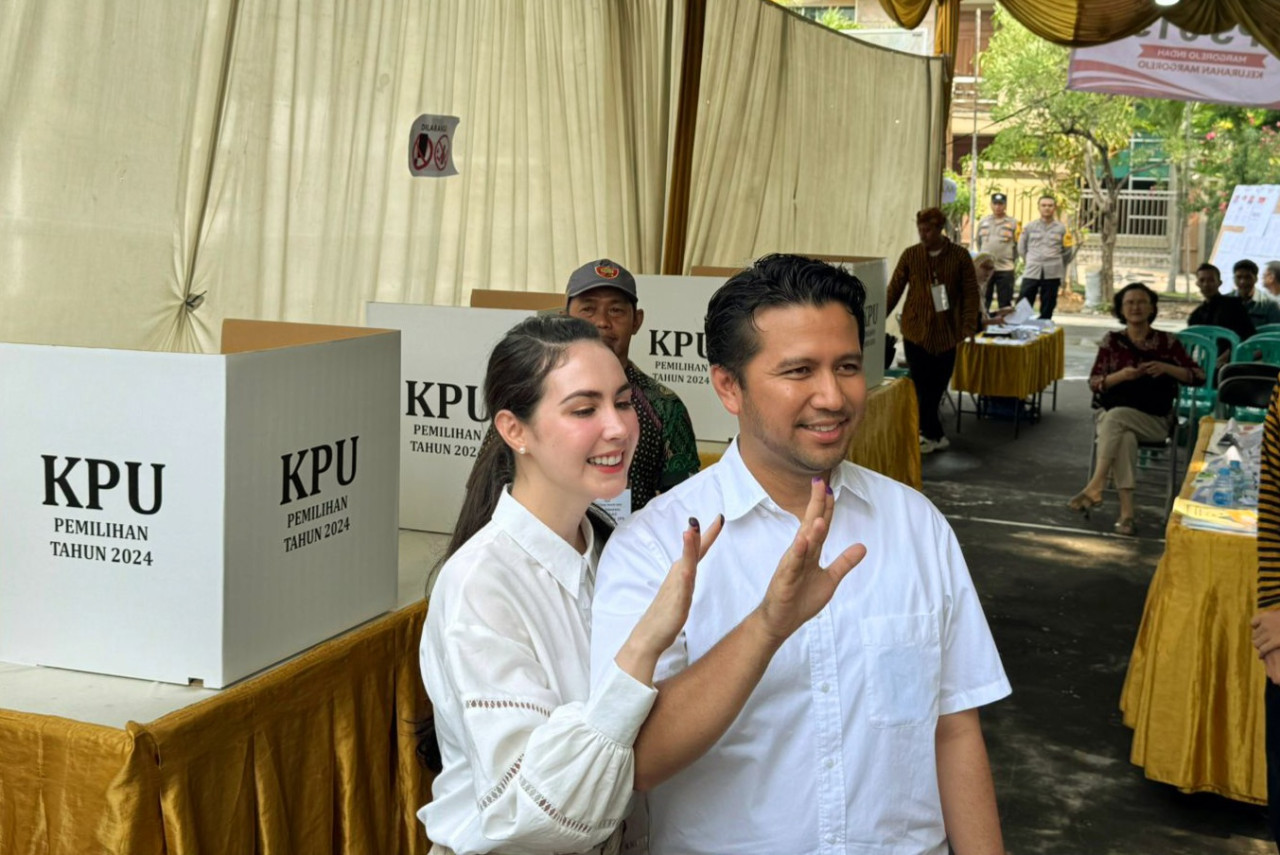 Emil dan Arumi saat nyoblos di TPS 15 Margorejo, Surabaya (foto: Ni'am Kurniawan/jatimnow.com)