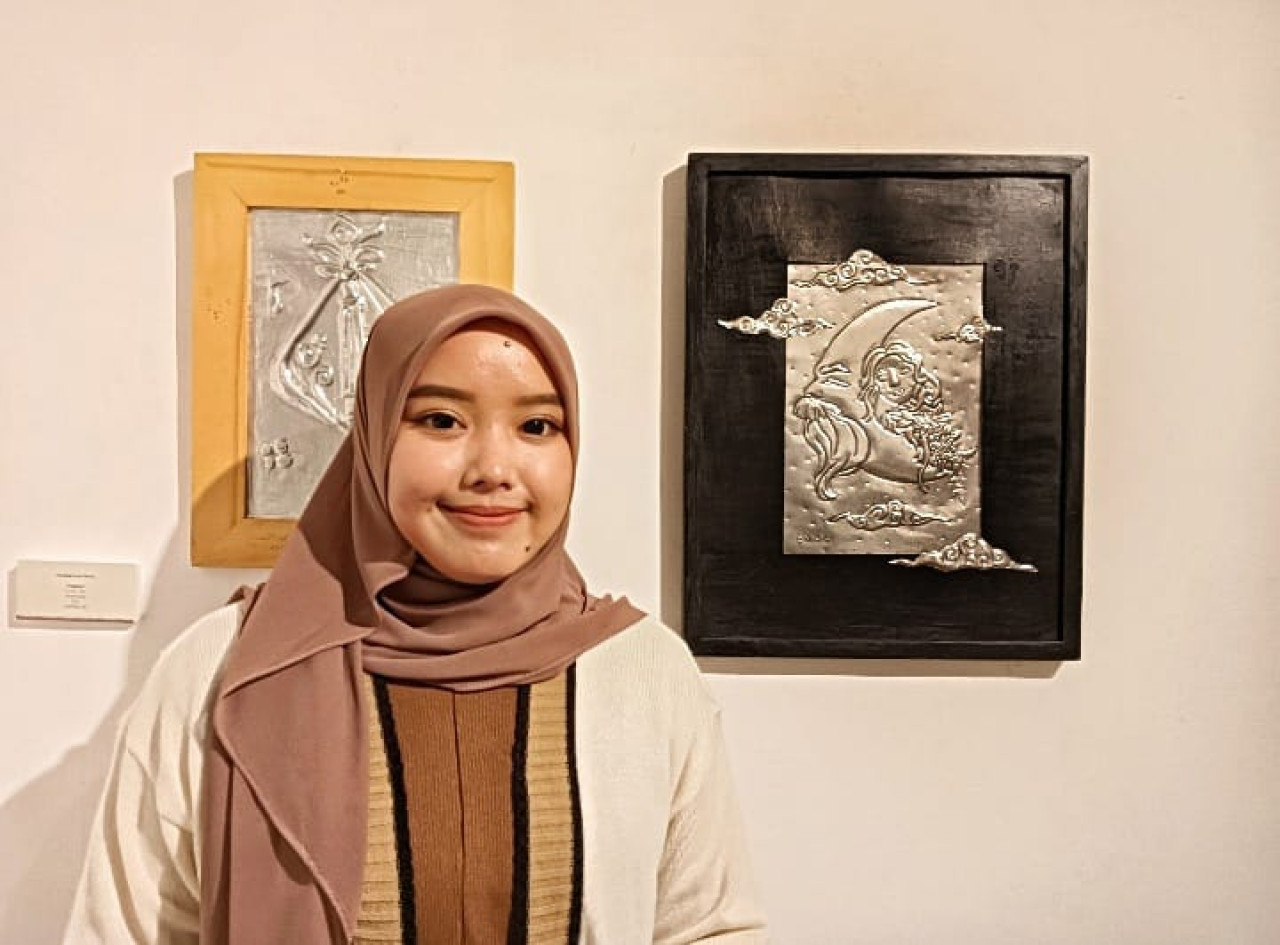 Nur Awwalur Rohmah dengan lukisan pelat seng buatannya di Hari Ayah Nasional. (Foto: Ahaddiini HM/jatimnow.com)