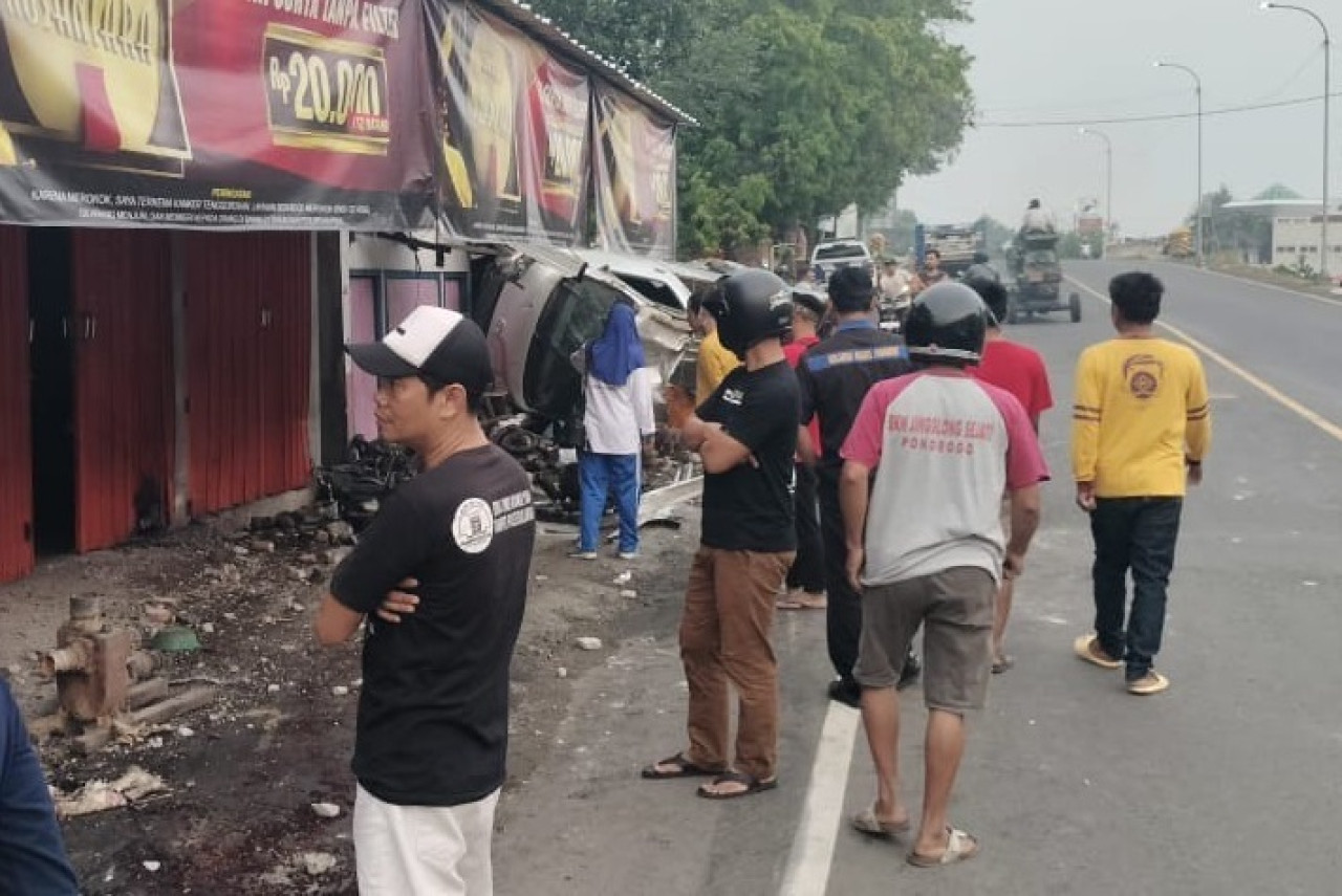 Pikap bermuatan jeroan ayam yang menabrak bengkel dan kios di Ponorogo. (Foto: Ahmad Fauzani/jatimnow.com)