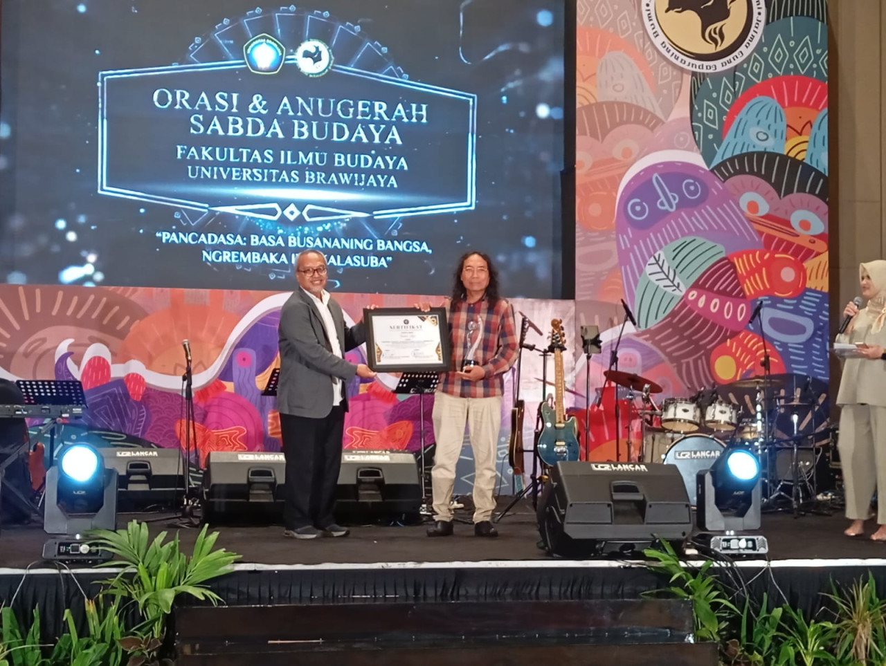 Penghargaan diserahkan oleh Wakil Rektor V Universitas Brawijaya, Prof Dr Unti Ludigdo SE., M.Si., Ak., kepada Ketua Teater Api Indonesia Mochammad Saleh. (Foto: Endang Pergiwati/jatimnow.com)