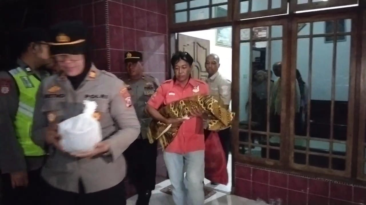 Polisi saat membawa bayi untuk diautopsi. (Foto: Bramanta Pamungkas/jatimnow.com)