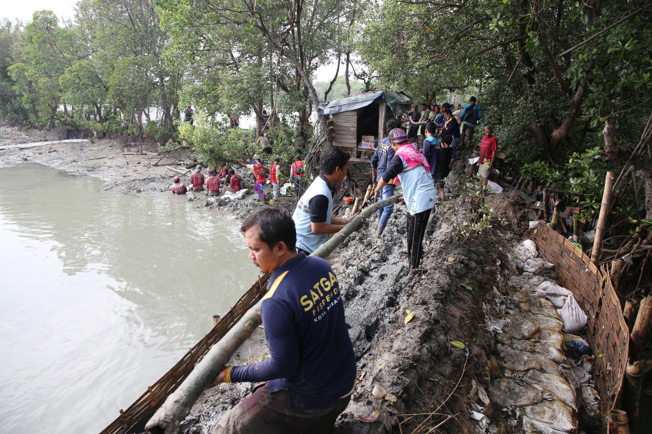 Warga gotong royong menambal dan meninggikan tanggul di pesisir laut (foto-foto: Humas Pemkot Surabaya for jatimnow.com)