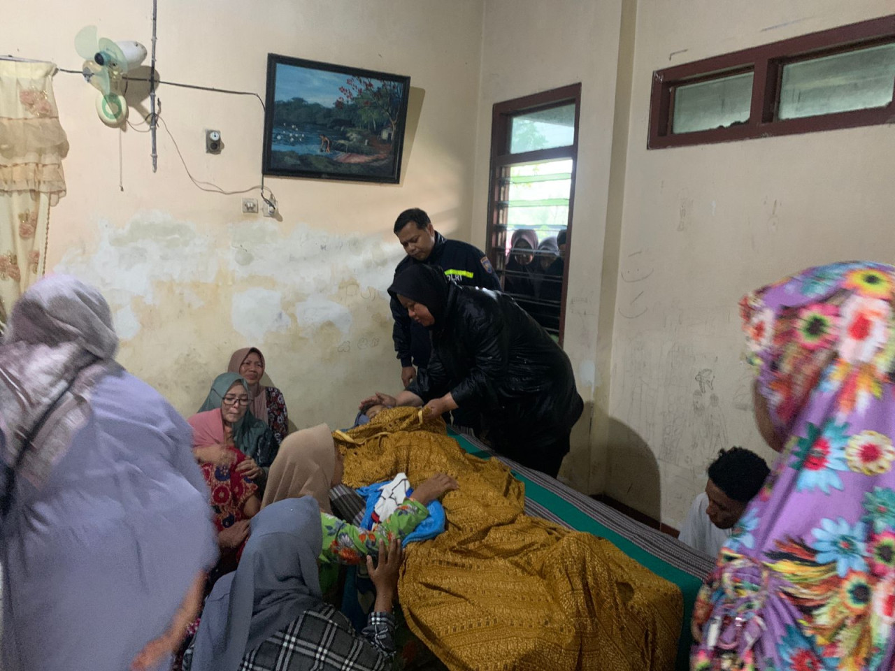Keluarga korban MDM yang berduka saat jenazah MDM tiba di rumah duka. (Foto : Adyad Ammy Iffansah/jatimnow.com)