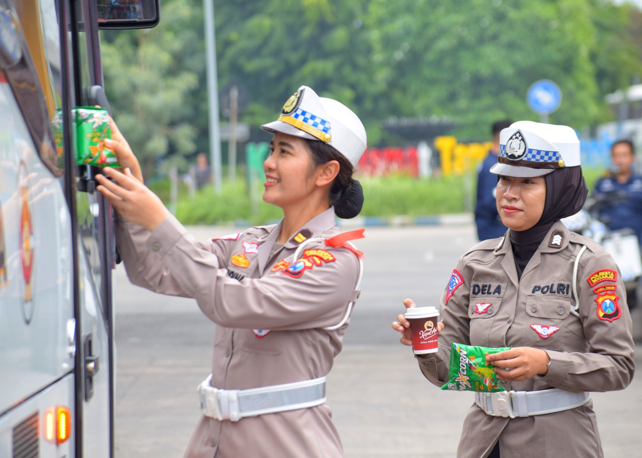 Para Polwan Polresta Sidoarjo membagikan kopi gratis dan snack ke sejumlah penumpang bus di Terminal Purabaya Bungurasih Waru Sidoarjo. (Foto: Ahaddiini HM/jatimnow.com).
