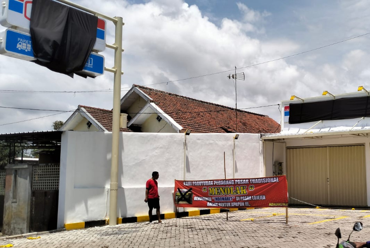 Banner penolakan Indomaret dipasang oleh warga. (Foto: Sugianto/jatimnow.com)