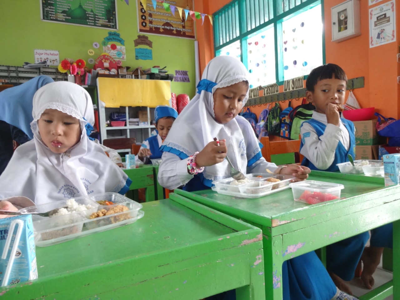 Siswa menikmati menu Makanan Bergizi Gratis. (Foto: Bramanta Pamungkas/jatimnow.com)