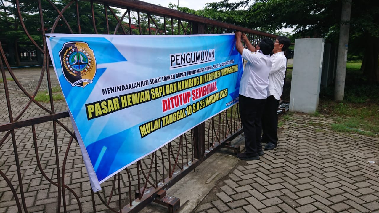 Petugas memasang pengumuman penutupan operasional pasar hewan di Tulungagung. (Foto: Bramanta Pamungkas/jatimnow.com)