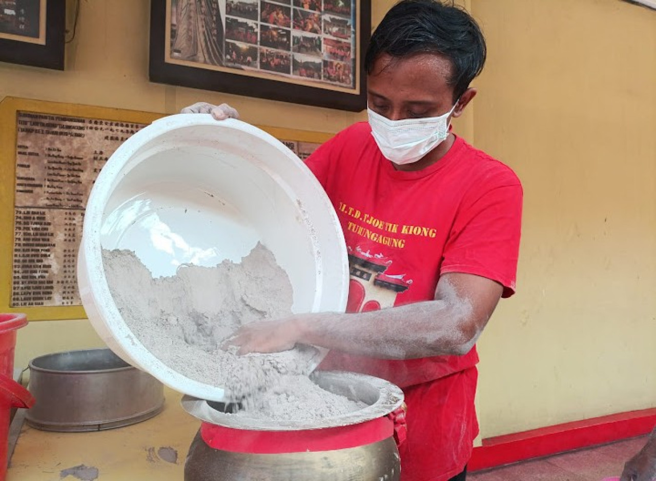 Pekerja di Kelenteng Tjoe Tik Kiong Tulungagung melakukan tradisi ayak abu. (Foto: Bramanta Pamungkas/jatimnow.com)
