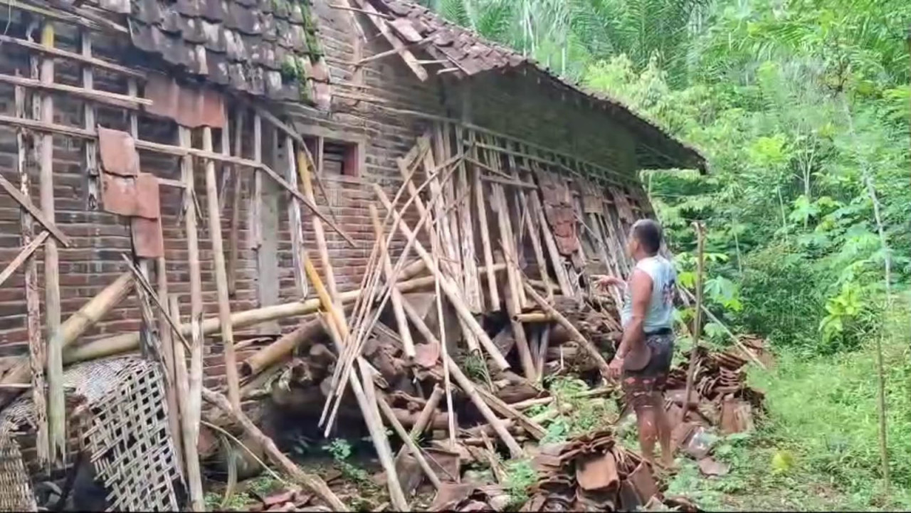 Warga menunjukkan salah satu rumah yang terdampak tanah gerak di Trenggalek. (Foto: Bramanta Pamungkas/jatimnow.com)