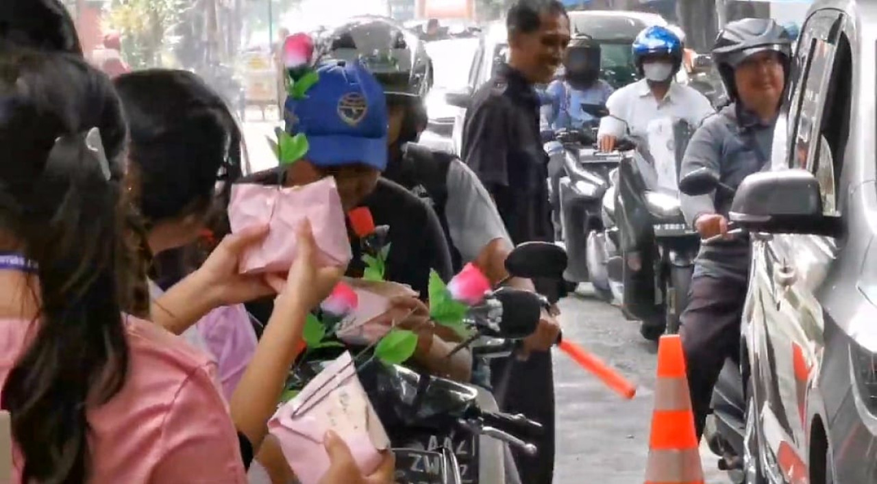 Siswa SMAK Untung Suropati Sidoarjo membagikan ratusan nasi bungkus cinta (Nasbucin) disertai kata- kata cinta dan bunga mawar di Hari Valentine. (Foto: Ahaddiini HM/jatimnow.com)
