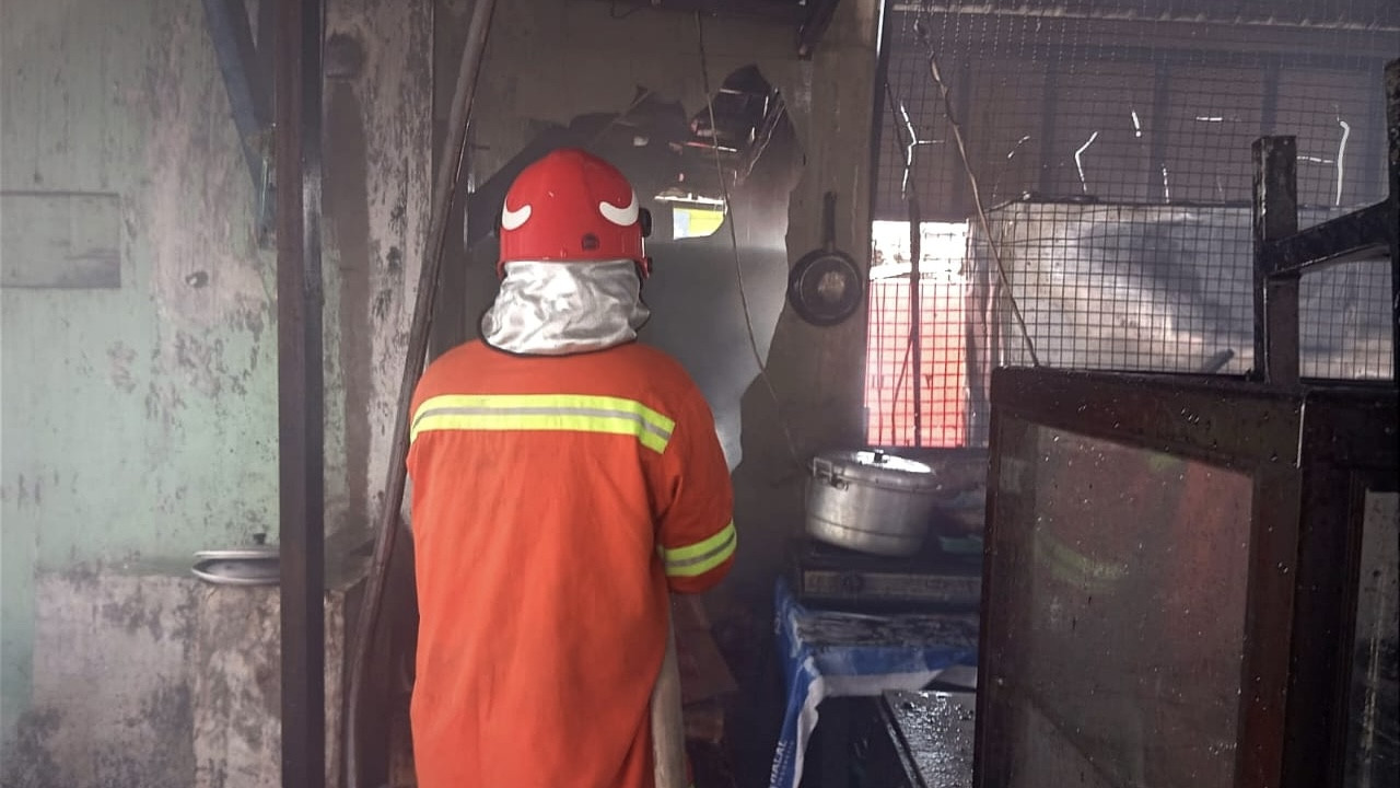 Petugas Damkarla Gresik saat memadamkan api yang membakar warung di Desa Manyarrejo, Gresik. (Foto: Damkarla Gresik)