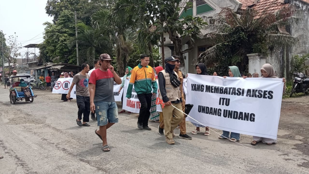 Emak-emak mengawal pengukuran rencana perbaikan jalan rusak Puger Jember. (Foto: Sugianto/jatimnow.com)