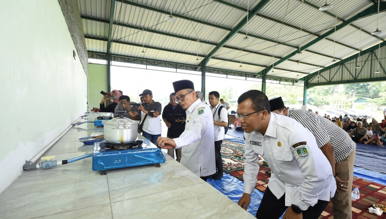 Wabup Pasuruan, HM. Shobih Asrori mencoba memasak telur ceplok dari api yang dihasilkan gas metana. (Foto:  Kominfo Pemkab Pasuruan for jatimnow.com)
