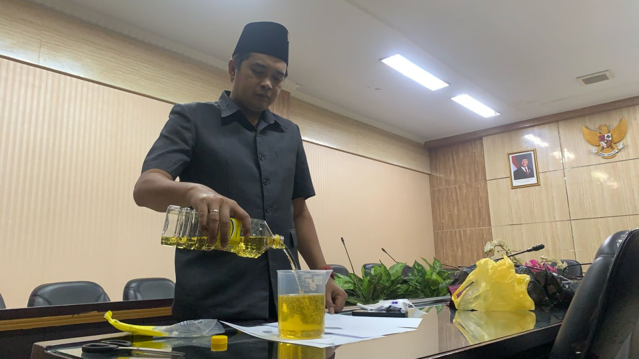 Ketua Komisi B DPRD Jember uji volume minyakita. (Foto: Sugianto/jatimnow.com)